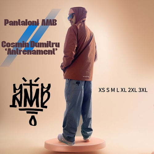 Person wearing a brown jacket and blue jeans on a beige background with 'Pantaloni AMB' branding.